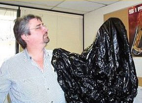 Man with arm in garbage bag - arm is INvisible